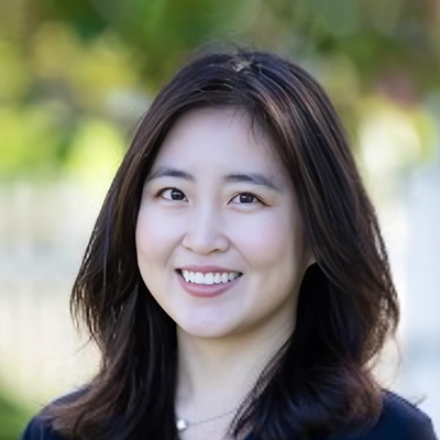 Dentist Christine Kwon Smiling Outdoors In Front Of Blurred Background