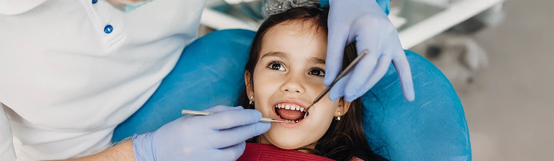 Happy Little Girl Receiving Dental Exam From Gentle Examiner