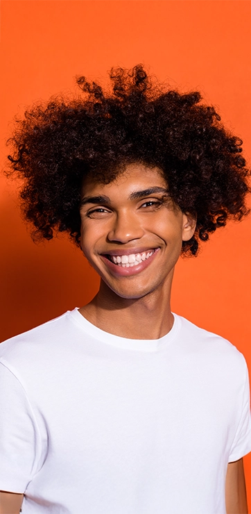 Person With Bright Smile In Front Of Bright Orange Background